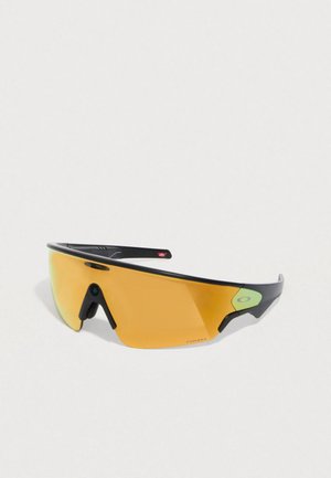 Sportsonnenbrille mit einem schlanken schwarzen Rahmen, bernsteinfarbenen Gläsern und grünen Logoakzenten. Die Form der Gläser ist gebogen für aerodynamische Leistung.