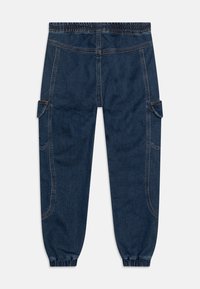 Jeans z elastycznym pasem, ciemny odcień, zwężane nogawki oraz kieszenie boczne. Charakteryzują się kontrastowym szwem i gładką fakturą.