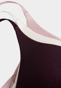 Drie cami straps in verschillende kleuren: diep paars, lichtroze en crème, gemaakt van zachte stof met een gladde textuur.