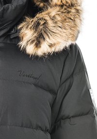 Sort pufferjakke med en kunstpels hættekant, der har quiltet tekstur og broderet "Vertical" logo på forsiden.