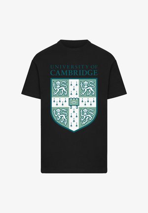 Black cotton t-shirt featuring University of Cambridge emblem in teal and white, with lions and a shield design. Text above the emblem.