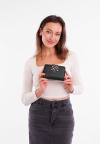 Black leather wallet with a polka-dotted flap, featuring a metal accent. Simple design, rectangular shape, and textured surface.