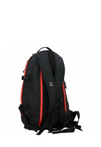 Mochila negra con rayas rojas, respaldo acolchado, correas ajustables, múltiples hebillas y una tela texturizada. Presenta un logo en el lateral.