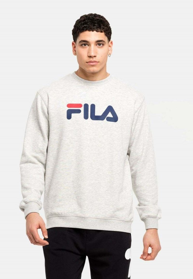 Pelēks flīsa krekls ar izteiksmīgu zilu 'FILA' logotipu ar sarkanu akcentu. Garas piedurknes un apaļa apkakles forma.
