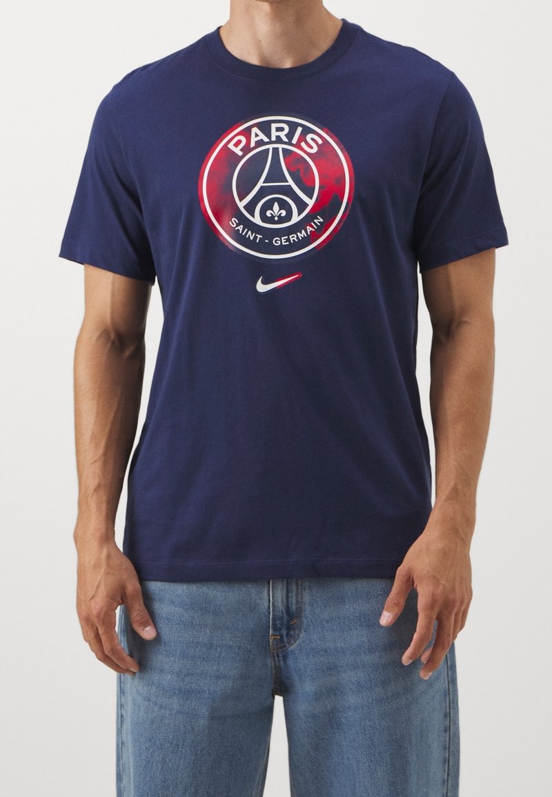 T-shirt en coton bleu marine avec un graphique rond portant le texte "PARIS" et "SAINT-GERMAIN", le logo Nike et l'emblème distinctif du club.