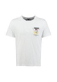 Camiseta blanca de manga corta con cuello redondo y un pequeño estampado en el pecho de un pájaro volando, salpicaduras amarillas y la palabra "ESPERO."