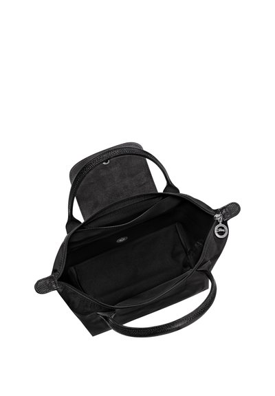 Black handbag with two handles, open top zipper, and magnetic flap showing spacious interior with one inner pocket.