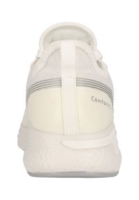 Vit idrottssko med ett ventilerande textilöverdrag, strukturerad sula och en bakre dragflik, med silverfärgade accentstrimmor på hälen.