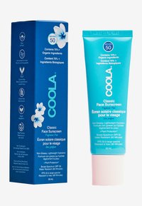 Krem przeciwsłoneczny Coola Classic Face, SPF 50, w turkusowej tubie z białym napisem. Pudełko zdobią kwiatowe grafiki oraz ikony ekologiczne.