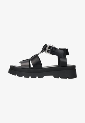 Zwarte plateau-sandalen van synthetisch leer. Heeft brede banden, een metalen sluiting en een gestructureerde zool voor grip.