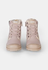 Rosa konstläder ankelstövlar med texturerade snören, fuskpälsfoder och beige gummisula. Har guldaccenter och rund tådesign.