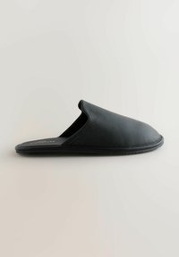 Black leather slipper with a smooth finish, open back, and rounded toe. Features a textured sole and minimalist design.