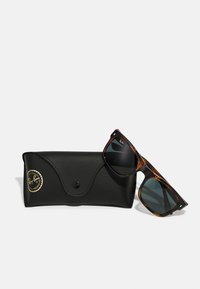Ochelari de soare Ray-Ban cu cadru din tortoise și lentile întunecate, însoțiți de o husă din piele neagră cu un logo aurie.