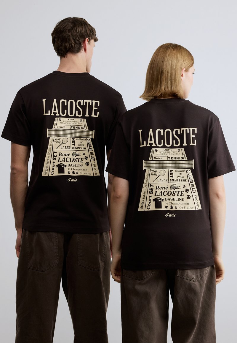 Μαύρο T-shirt με μεγάλο ταμπά γραφικό στην πλάτη, που περιλαμβάνει κείμενο και λογότυπα με θέμα το τένις. Κοντά μανίκια, σχέδιο με στρογγυλή λαιμόκοψη.