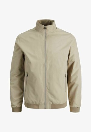 Helle beige Zip-Jacke mit Stehkragen, elastischen Bündchen und Saum. Verfügt über zwei seitliche Reißverschlusstaschen und eine glatte Außenstruktur.