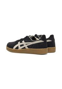 Black suede sneakers with a cream side stripe, gum rubber sole, and tonal stitching. Rounded shape with low-cut design for easy wear.