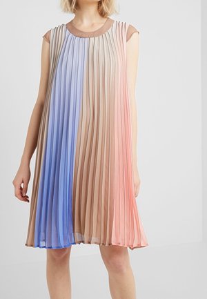 Ærmeløs plisseret kjole med vertikale striber i blå, beige og lyserøde toner, båret af en stående person mod en ensfarvet baggrund.