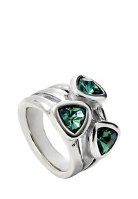 Bague en argent ornée de trois pierres précieuses triangulaires vertes, avec un design de bande ondulée et une texture polie mettant en valeur les sertissages des pierres.