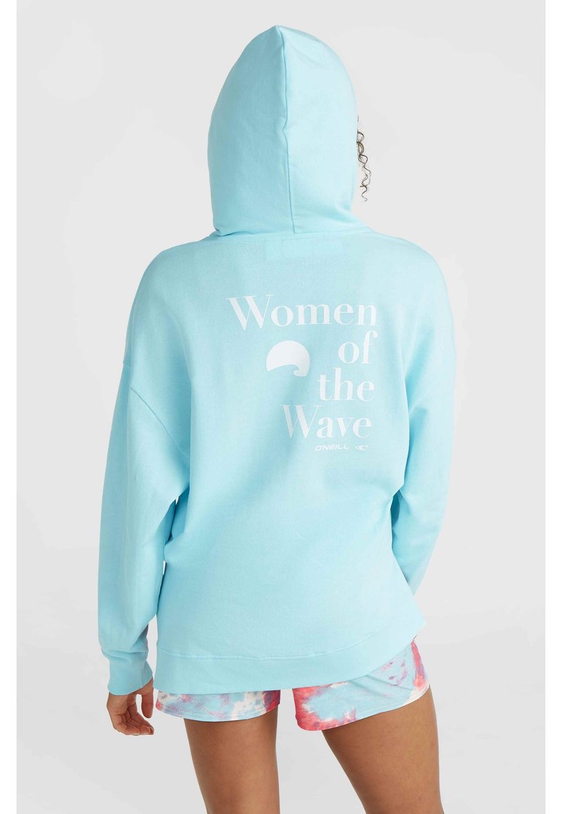 Light blue hoodie with a kangaroo pocket, featuring white text "Women of the Wave" on the back. Soft fabric and relaxed fit.