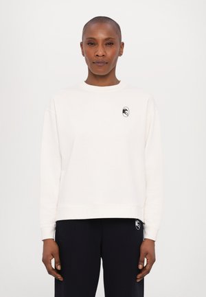 Cream sweatshirt with a round neckline, long sleeves, and a black logo on the chest. Soft fabric and relaxed fit design.