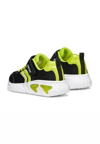 Sneakers nere in mesh con accenti verde neon, caratterizzate da una tomaia testurizzata, collo imbottito e suola in gomma bianca con dettagli di ventilazione.