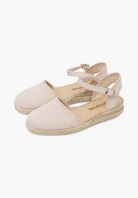 Espadrillas in tela rosa chiaro con suola in giuta, dotate di cinghie alla caviglia e design a punta arrotondata. Texture liscia con dettagli minimi.