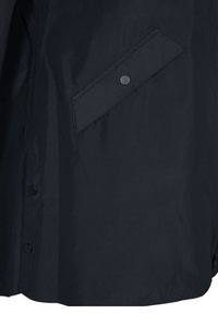 Navy waterproof jacket section with smooth texture, featuring a diagonal pocket with a snap closure and black buttons along the front.