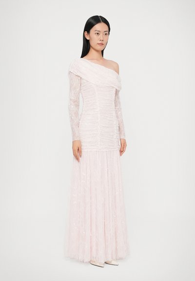 Różowa koronkowa suknia z dekoltem odkrywającym ramiona, długimi koronkowymi rękawami, marszczonym gorsetem i rozkloszowanym dołem. Całość ozdobiona wzorem kwiatowym.