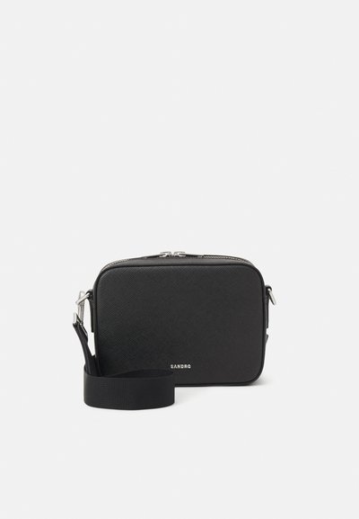 Bolso cruzado rectangular negro hecho de material texturizado con cierre de cremallera, que cuenta con una correa desmontable y un acento de logo plateado.