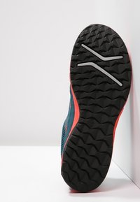 Hardloopschoen met een gestructureerde zwarte rubberen zool, een turquoise mesh bovenkant en koralen accenten. Heeft een gestroomlijnd ontwerp en een zichtbaar loop patroon.