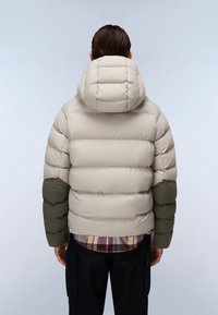 Puffer bunda s béžovým tělem, zelenými rukávy a prošívanou kapucí. Má hladký povrch a lehké zateplení pro teplo.