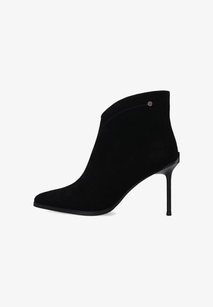 Černé semišové kotníkové boty s špičatou špičkou, vysokým jehlovým podpatkem, elegantním designem a jemným švem podél svršku.