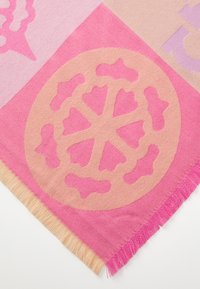 Sciarpa a motivi rosa e beige con un design circolare caratterizzato da forme ritagliate e bordi frangiati. Realizzata in un morbido tessuto testurizzato.