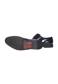 Eleganti scarpe da uomo in pelle nera lucida con design allacciato, una scarpa presenta una suola liscia con grip a motivo e tacco.