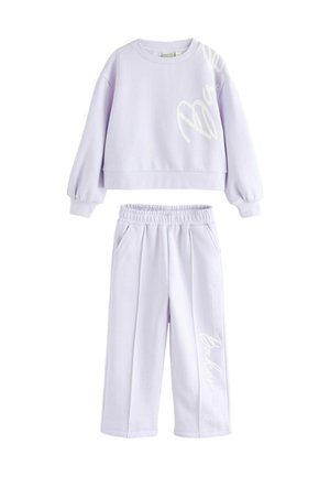Liliowy dwu-elementowy zestaw składający się z krótkiego swetra z długimi rękawami oraz spodni z szerokimi nogawkami i elastycznym pasem, oba z białymi akcentami tekstowymi.