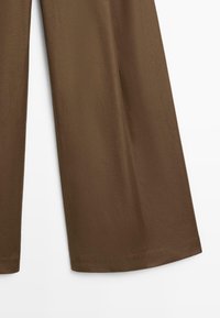 Bruine wijde broek met nette zomen, afgebeeld tegen een witte achtergrond.