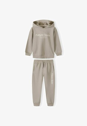 Hoodie beige clair avec le logo "Future Skate", accompagné d'un pantalon de survêtement assorti présentant une taille élastique et des poignets, le tout en tissu doux.