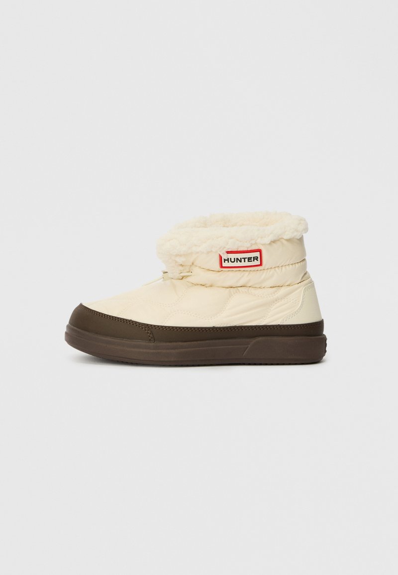 Cream and brown insulated ankle boots with fleece lining and Hunter logo patch on the side, winter footwear for cold weather.