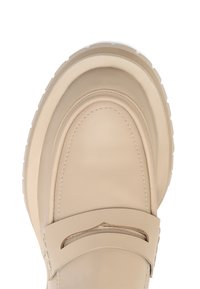 Mocasín de cuero beige con puntera redonda, costuras sutiles y un acento recortado en la parte superior. Suela de goma blanca gruesa.