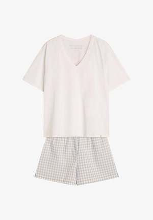 Biała koszulka z krótkim rękawem w serek z bawełny, zestawiona z krótkimi spodniami w jasnoniebieską kratkę. Prosty, casualowy zestaw do relaksu.