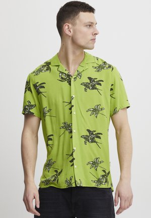 Green short-sleeve shirt with black tropical leaf pattern, collared design, lightweight fabric, and button closure on the front.