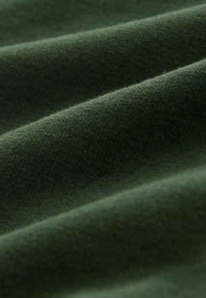 Dunkelgrüner Stoff mit einer weichen, strukturierten Oberfläche, die sanfte Falten und ein glattes, leicht gebürstetes Aussehen zeigt.
