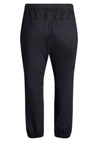 Pantalones jogger negros con cintura elástica, dos bolsillos traseros y puños ajustados en los tobillos. Hechos de una tela suave y texturada.