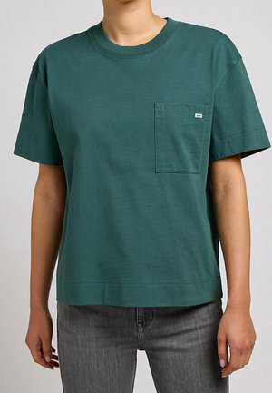 T-shirt en coton vert avec un col rond, des manches courtes et une poche sur la poitrine. Il présente une coupe décontractée et des détails de couture minimalistes.
