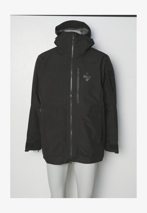 Schwarze wasserdichte Jacke mit hohem Kragen, durchgehendem Reißverschluss und zwei großen Taschen. Mit Logo und verstellbaren Manschetten.