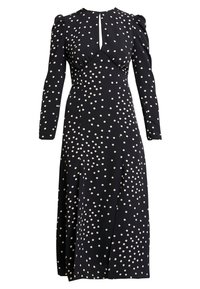 Svart klänning med långa ärmar, vita prickar och en nyckelhålsutskärning. Mjuk tyg, figursydd midja och en luftig kjol med en sidoklyvning.