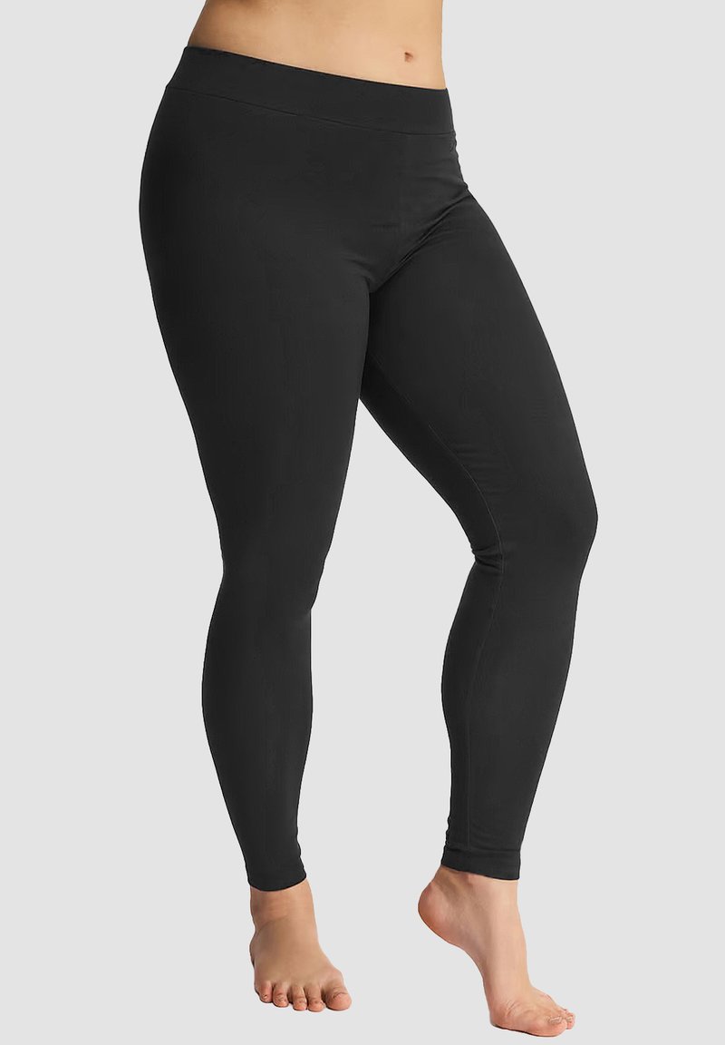 Schwarze Leggings mit glatter Textur, hohem Bund und langem Design. Sitzt eng am Körper an, ohne sichtbare Nähte.