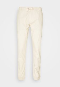 Pantalones jogger de algodón color beige claro con cintura elástica y cordón, diseño de pierna ajustada, que presentan una textura suave y sin patrones visibles.
