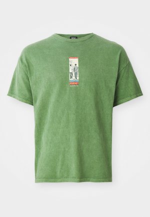 Green cotton t-shirt featuring a central graphic label with the word "JOURNEY," short sleeves, and a relaxed fit. Soft texture, casual design.