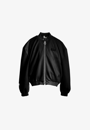 Chaqueta bomber negra hecha de tela suave, con cremallera frontal, puños elásticos y un corte corto con una etiqueta de acento.